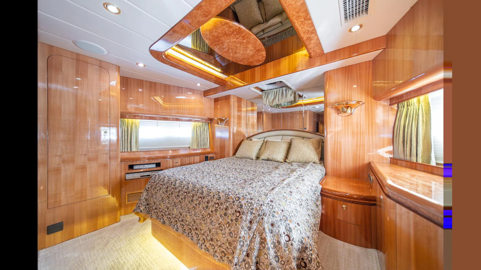 The master stateroom features luxurious wood paneling and a plush bed with elegant bedding. aboard WISHES GRANTED Yacht for Sale