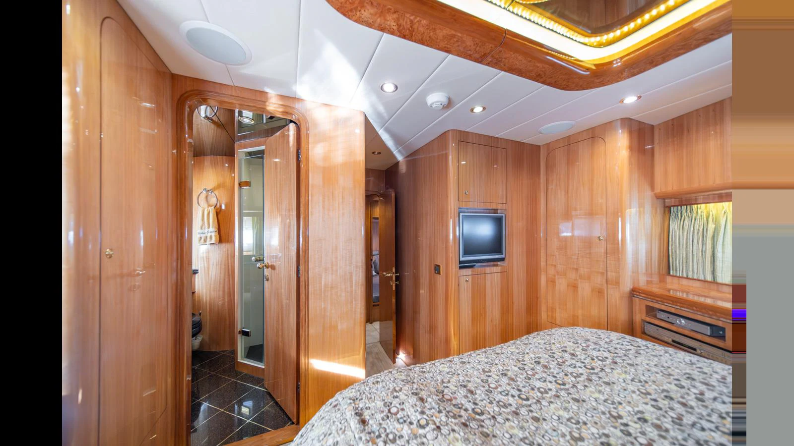 The stateroom features luxurious wood paneling and modern amenities for a comfortable stay. aboard WISHES GRANTED Yacht for Sale