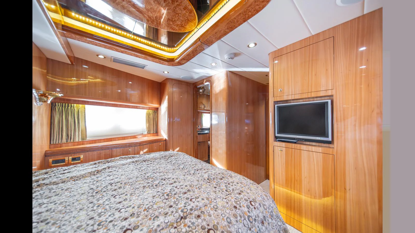 The stateroom features luxurious wood paneling and modern amenities for a comfortable stay. aboard WISHES GRANTED Yacht for Sale