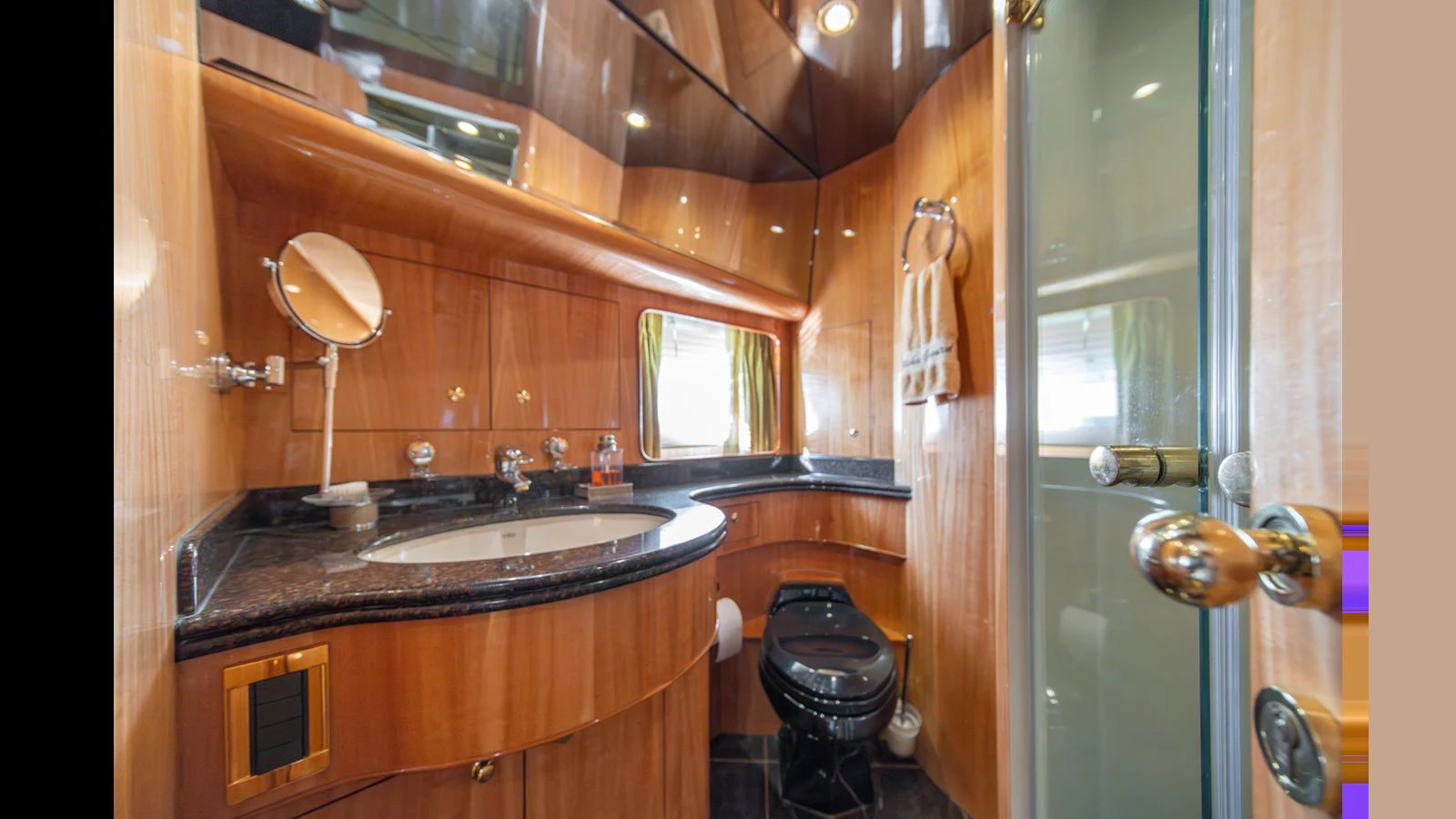 The yacht's bathroom features elegant wood paneling and modern fixtures. aboard WISHES GRANTED Yacht for Sale