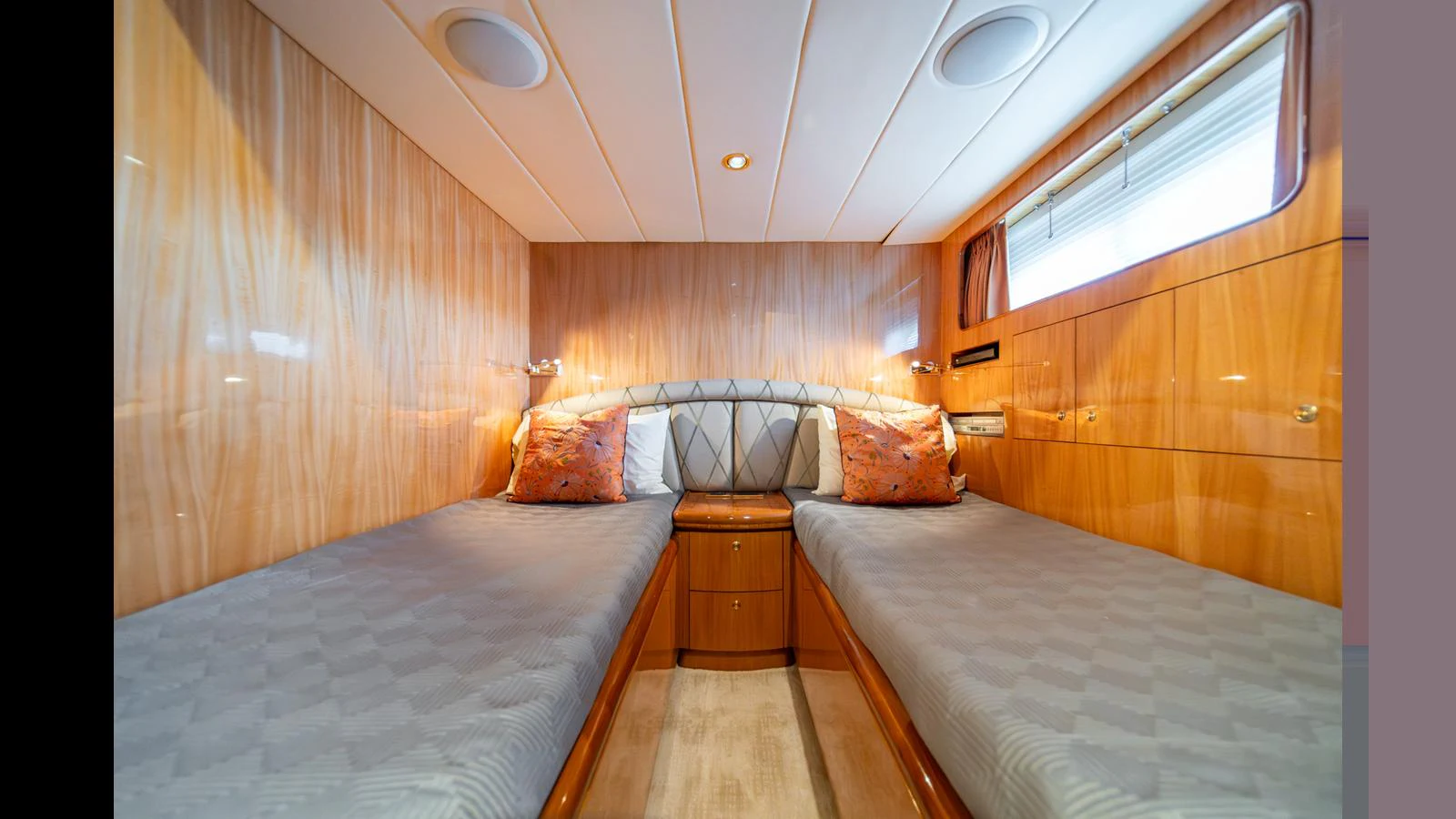 The twin stateroom features two comfortable single beds with elegant wood paneling and soft lighting. aboard WISHES GRANTED Yacht for Sale