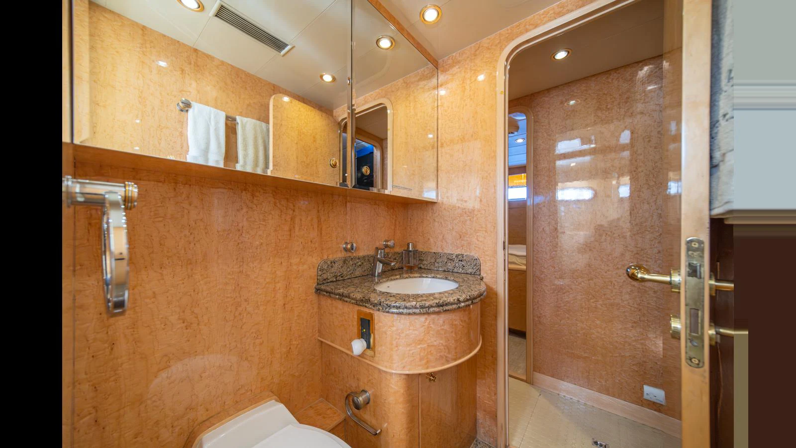The yacht's bathroom features elegant wood paneling and a granite countertop. aboard WISHES GRANTED Yacht for Sale