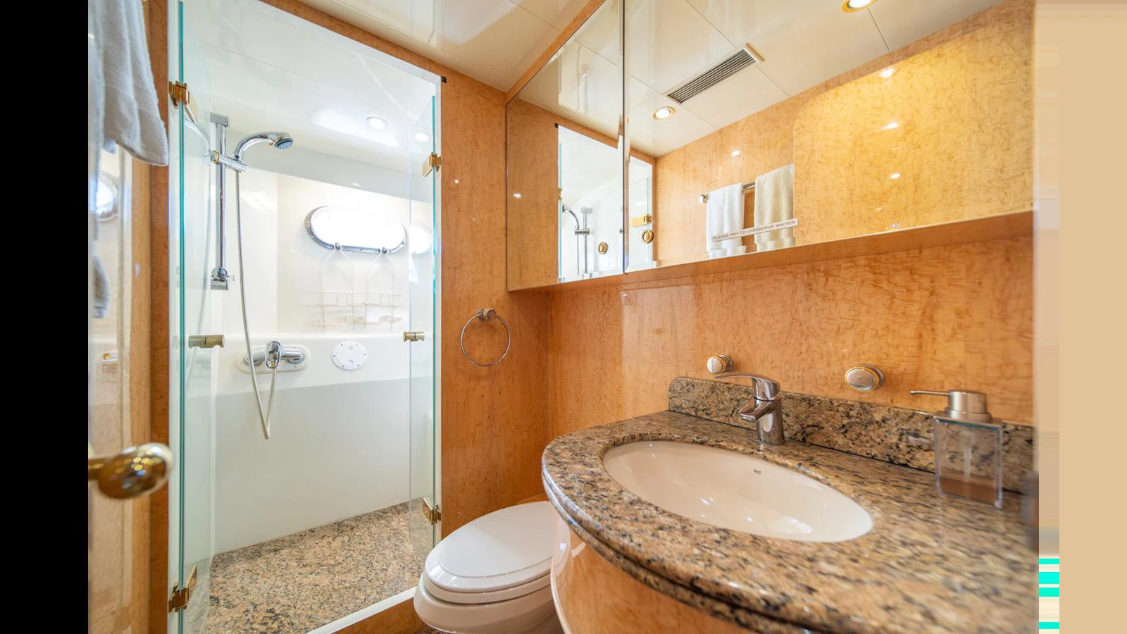 A luxurious bathroom with a granite countertop and a spacious shower area. aboard WISHES GRANTED Yacht for Sale