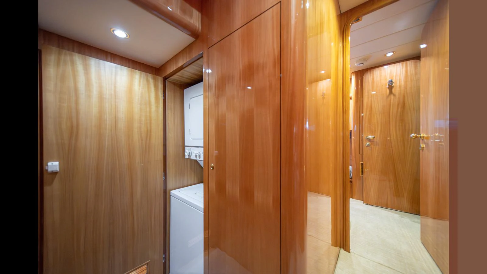 The image showcases a polished wooden hallway with a laundry area on a luxury yacht. aboard WISHES GRANTED Yacht for Sale
