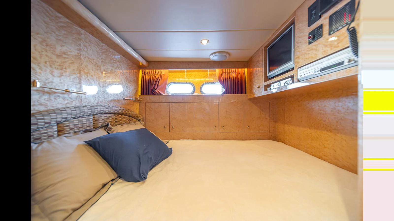 A cozy stateroom with a comfortable bed and built-in entertainment system. aboard WISHES GRANTED Yacht for Sale