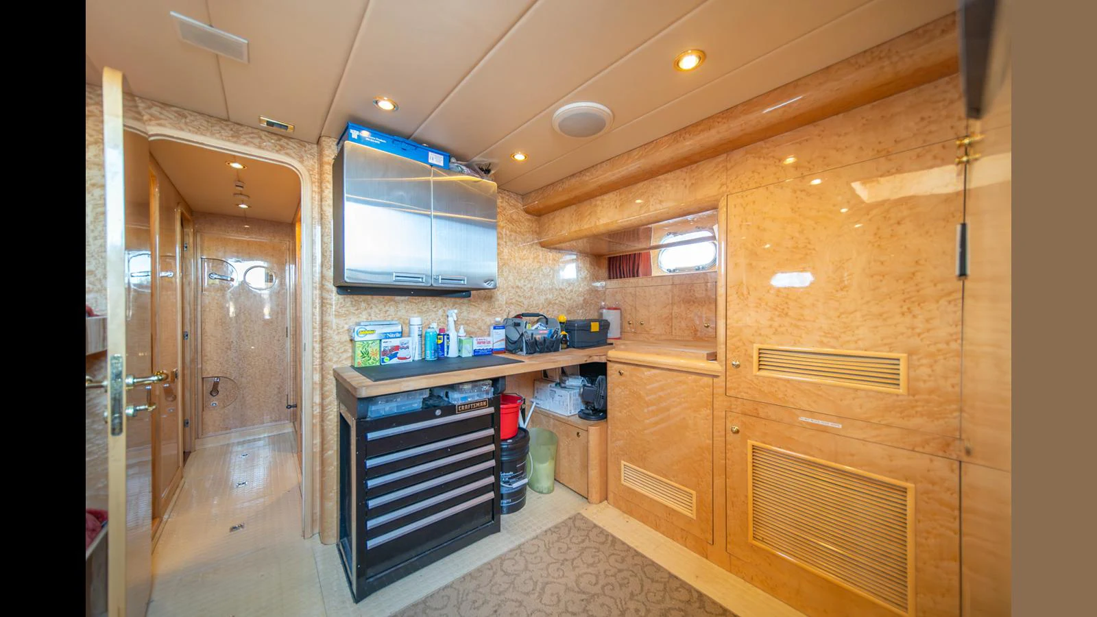 The crew area features practical storage and workspace with warm wood finishes. aboard WISHES GRANTED Yacht for Sale