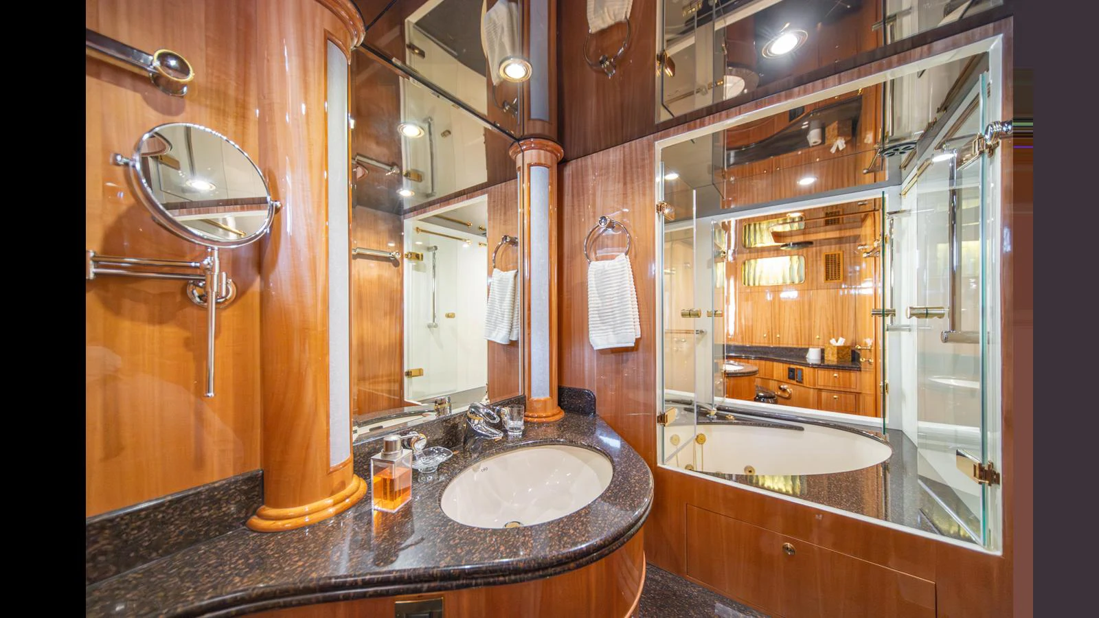 The yacht's bathroom features elegant wood paneling and a sleek countertop with modern fixtures. aboard WISHES GRANTED Yacht for Sale