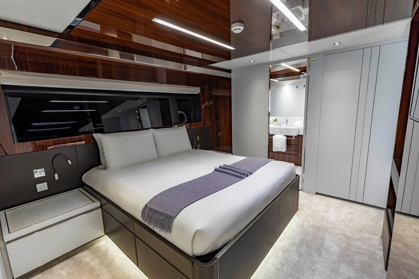 A luxurious stateroom featuring a large bed with modern decor and ambient lighting. aboard NO SURRENDER Yacht for Sale