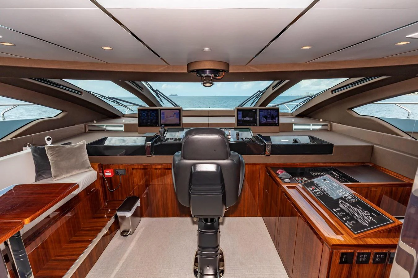 The helm station offers a sophisticated command center with advanced navigation equipment and luxurious wood finishes. aboard NO SURRENDER Yacht for Sale