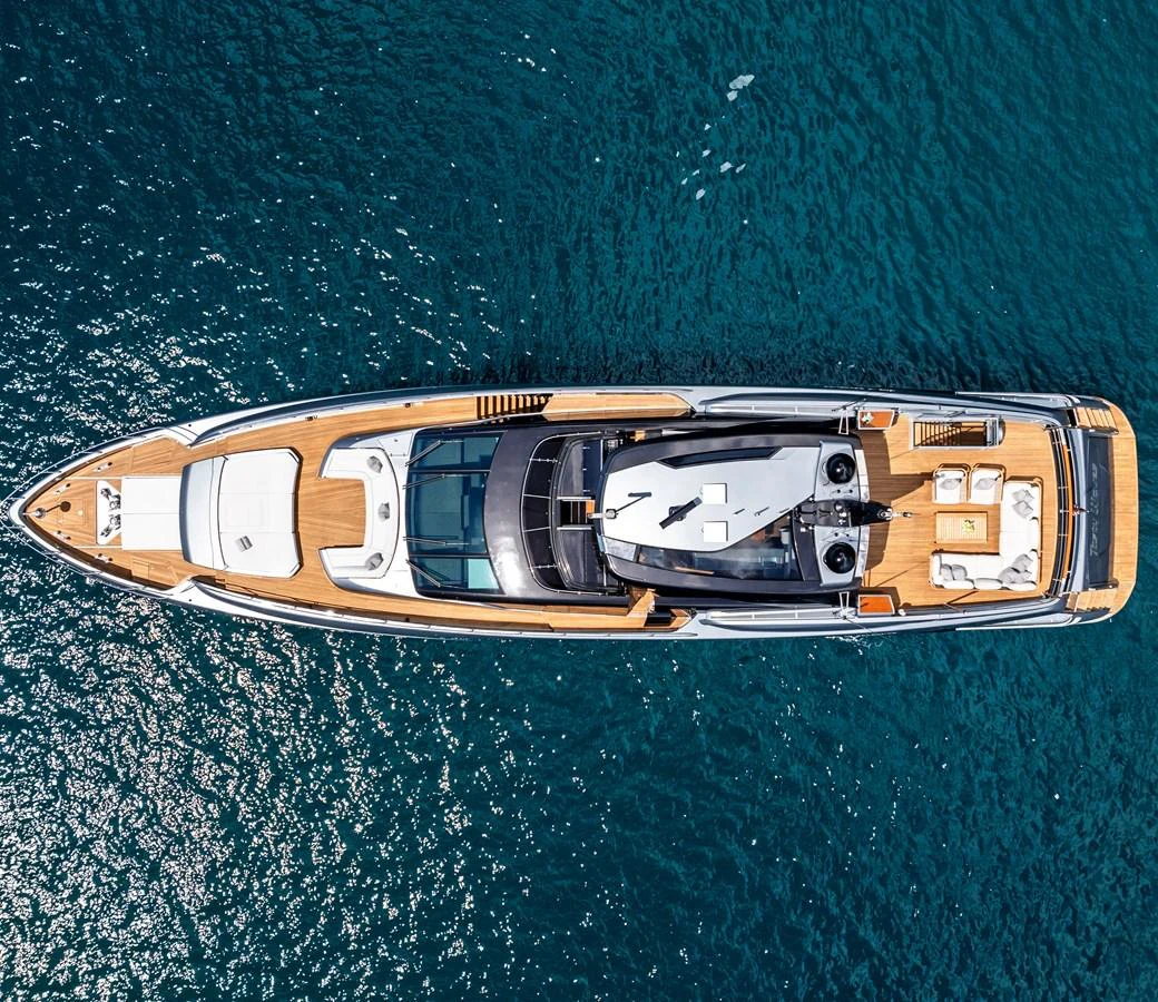 A stunning aerial view of a sleek, modern yacht cruising on clear blue waters. aboard NO SURRENDER Yacht for Sale
