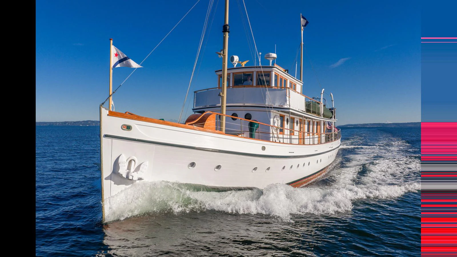 A classic yacht cruises gracefully on calm waters under a clear blue sky. aboard BLUE PETER Yacht for Sale