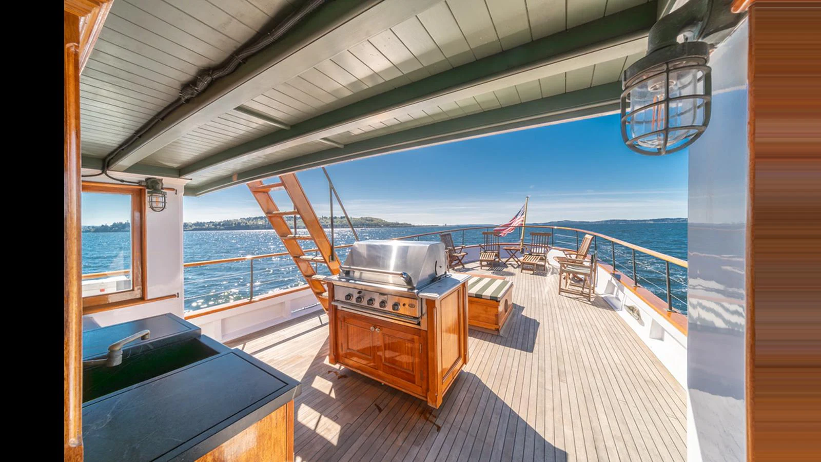The aft deck features a spacious outdoor area with a grill and seating, perfect for alfresco dining and relaxation. aboard BLUE PETER Yacht for Sale