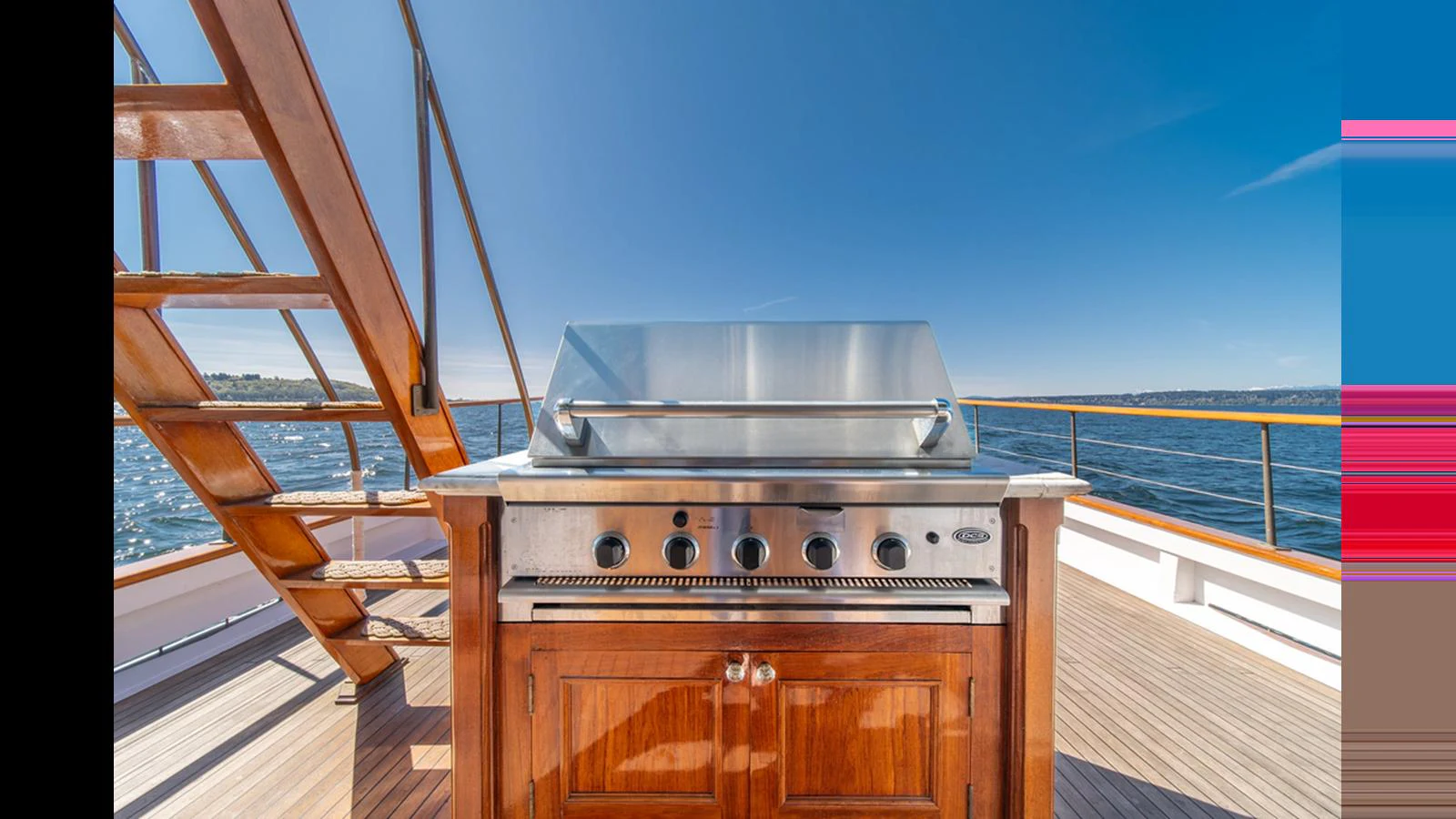 The yacht features a beautifully crafted wooden grill station on the deck, perfect for outdoor dining with a view of the sea. aboard BLUE PETER Yacht for Sale