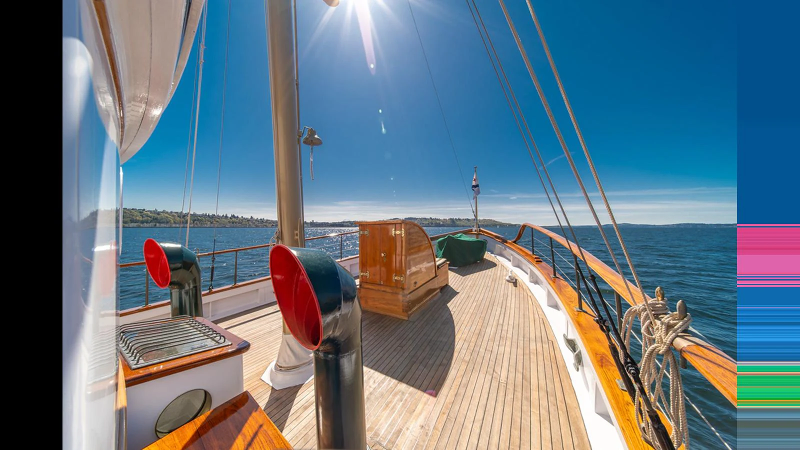 The yacht's deck offers a spacious and sunlit area with beautiful wood finishes and a clear view of the surrounding waters. aboard BLUE PETER Yacht for Sale