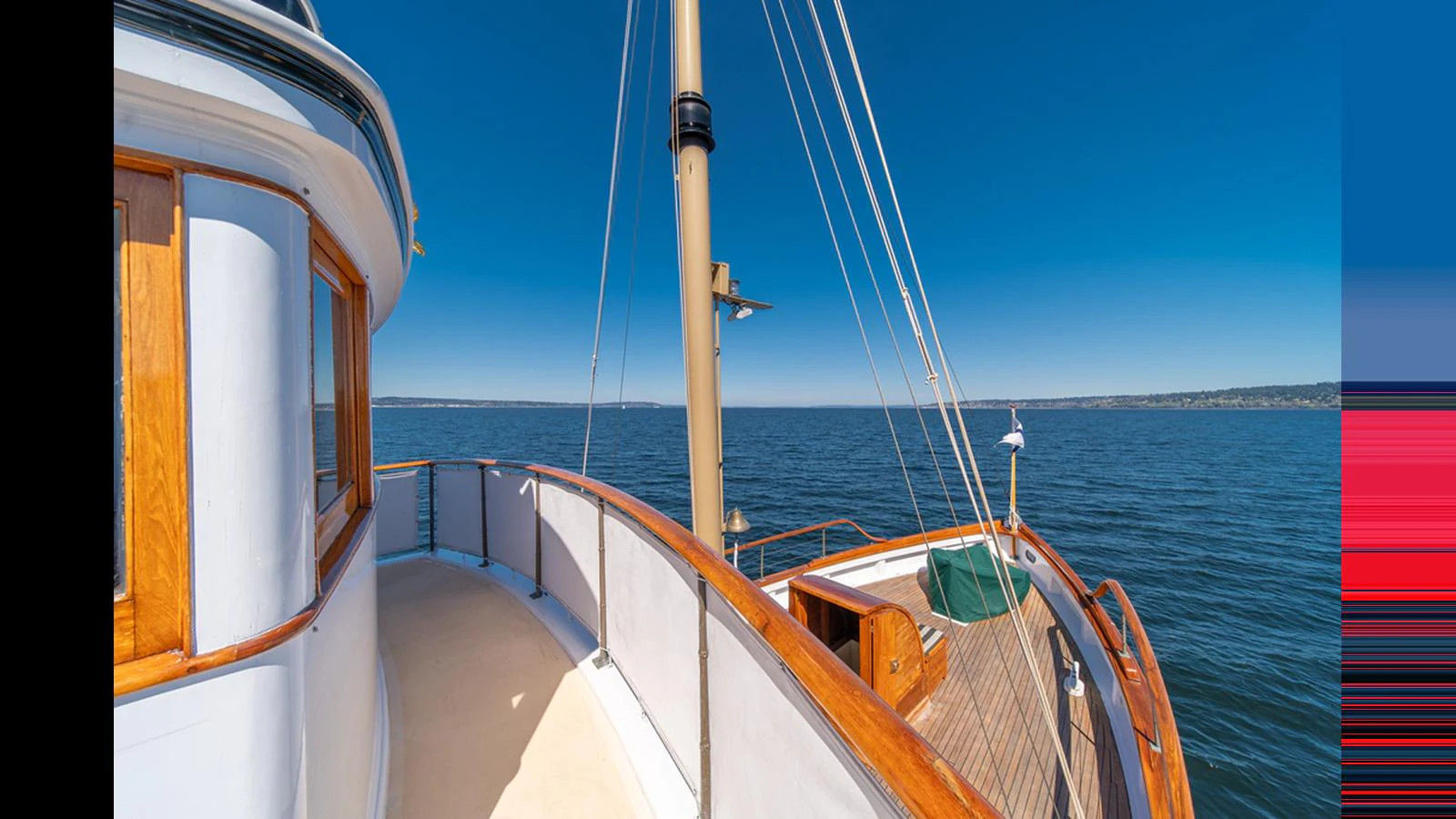 The yacht's deck offers a stunning view of the open sea under a clear blue sky. aboard BLUE PETER Yacht for Sale