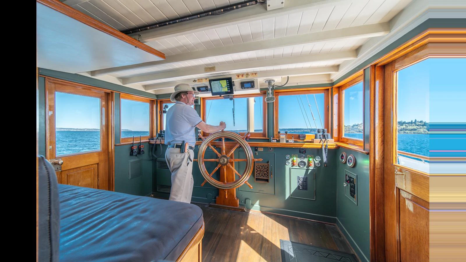 The helm station features classic wooden accents and modern navigation equipment, offering a blend of tradition and technology. aboard BLUE PETER Yacht for Sale