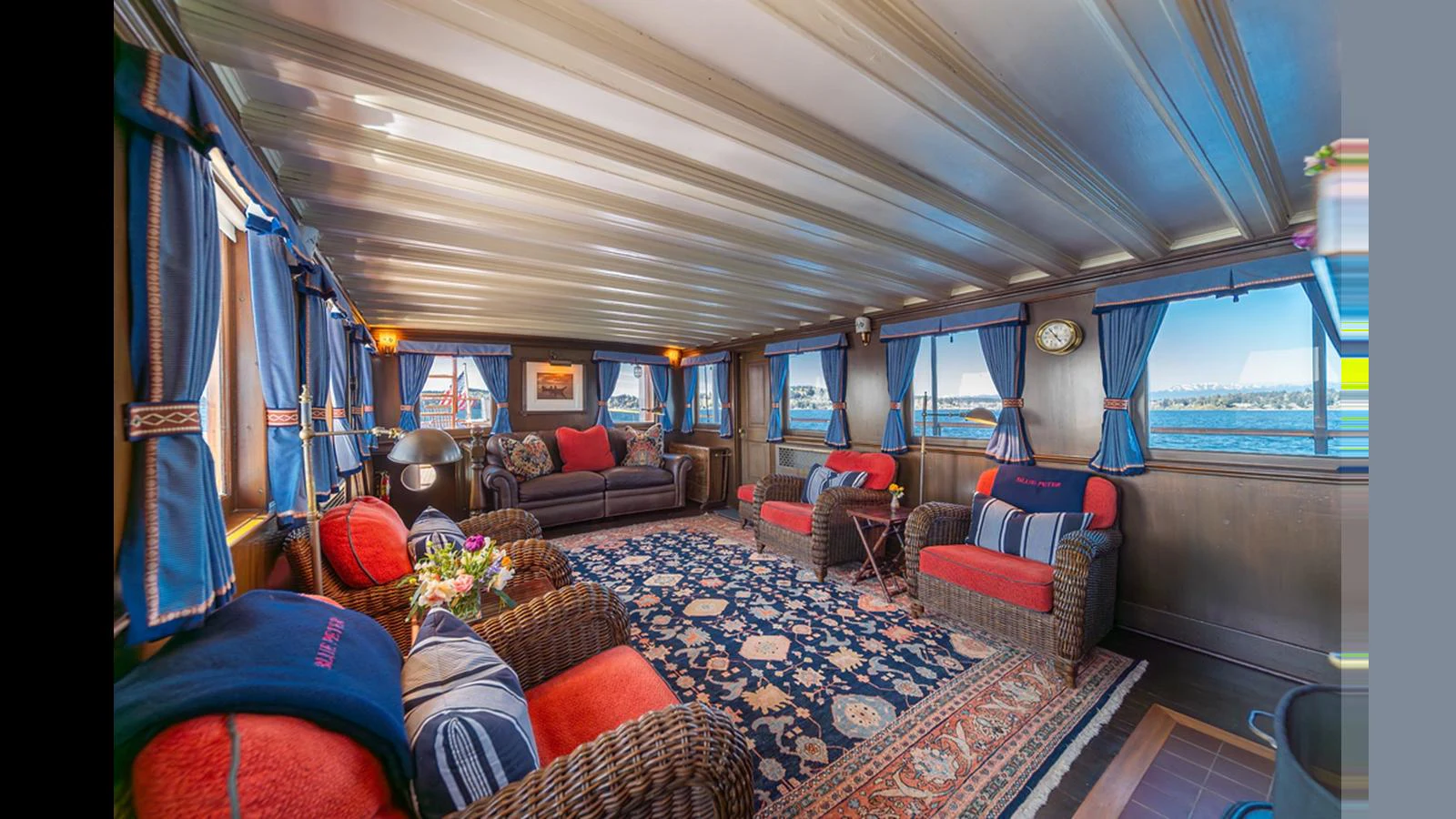 The yacht's salon features a spacious and inviting seating area with large windows offering panoramic views. aboard BLUE PETER Yacht for Sale