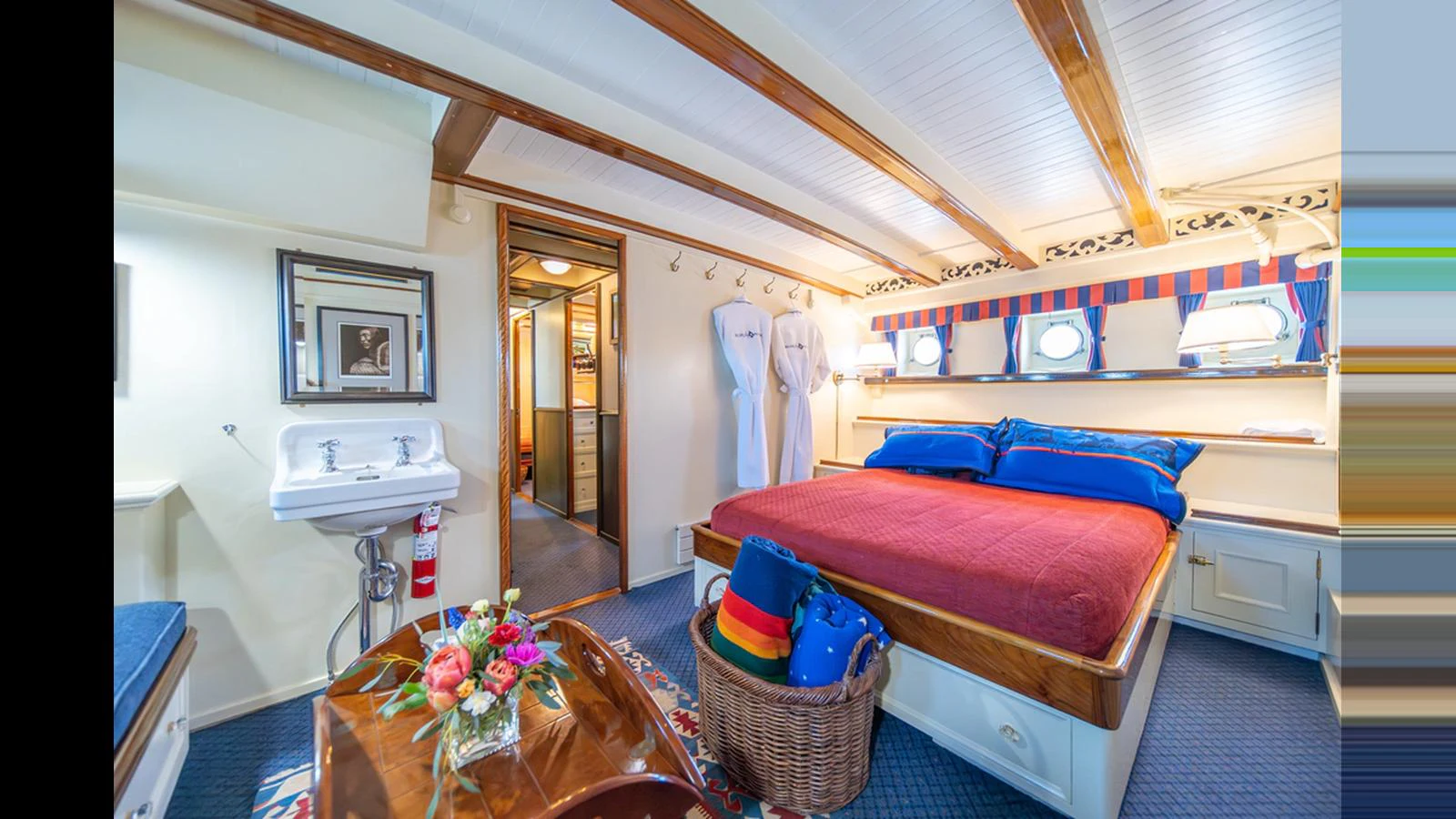 A cozy stateroom featuring a comfortable bed with vibrant linens and a charming nautical decor. aboard BLUE PETER Yacht for Sale