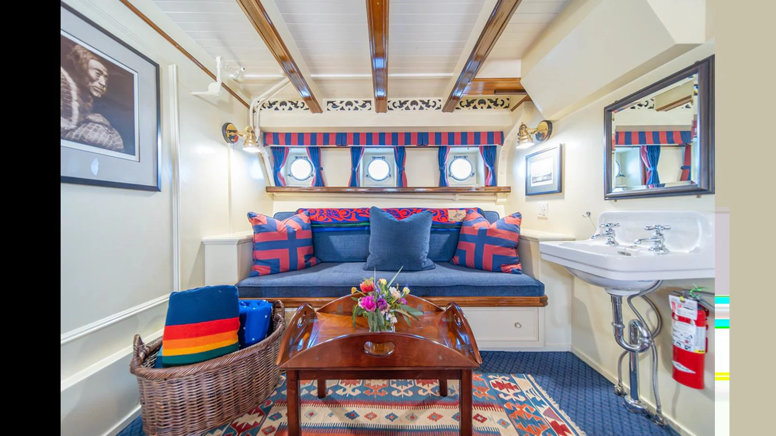 The cozy salon features a comfortable seating area with vibrant cushions and a charming nautical decor. aboard BLUE PETER Yacht for Sale