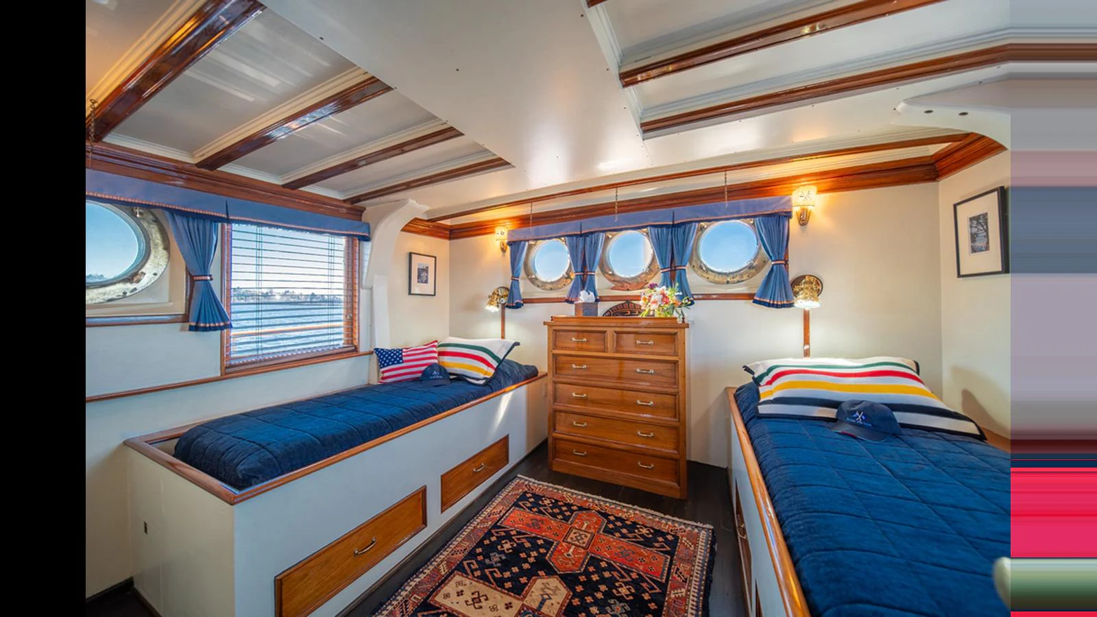 A cozy twin stateroom featuring two single beds, a chest of drawers, and nautical decor. aboard BLUE PETER Yacht for Sale