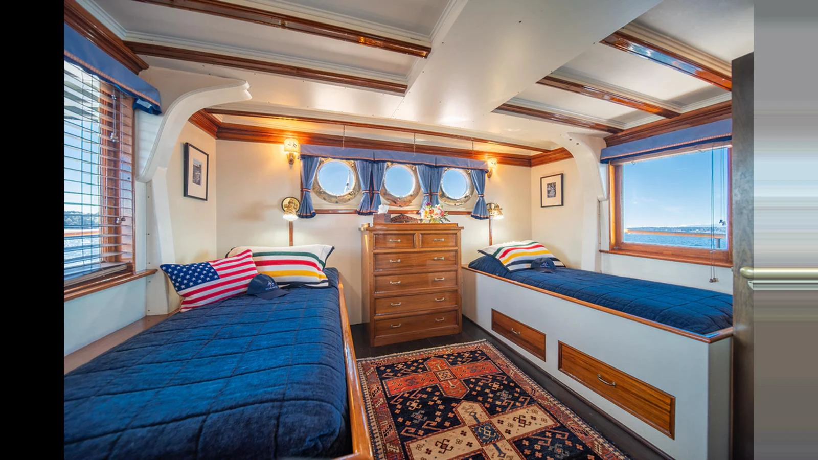A cozy twin stateroom with nautical decor and ample natural light. aboard BLUE PETER Yacht for Sale