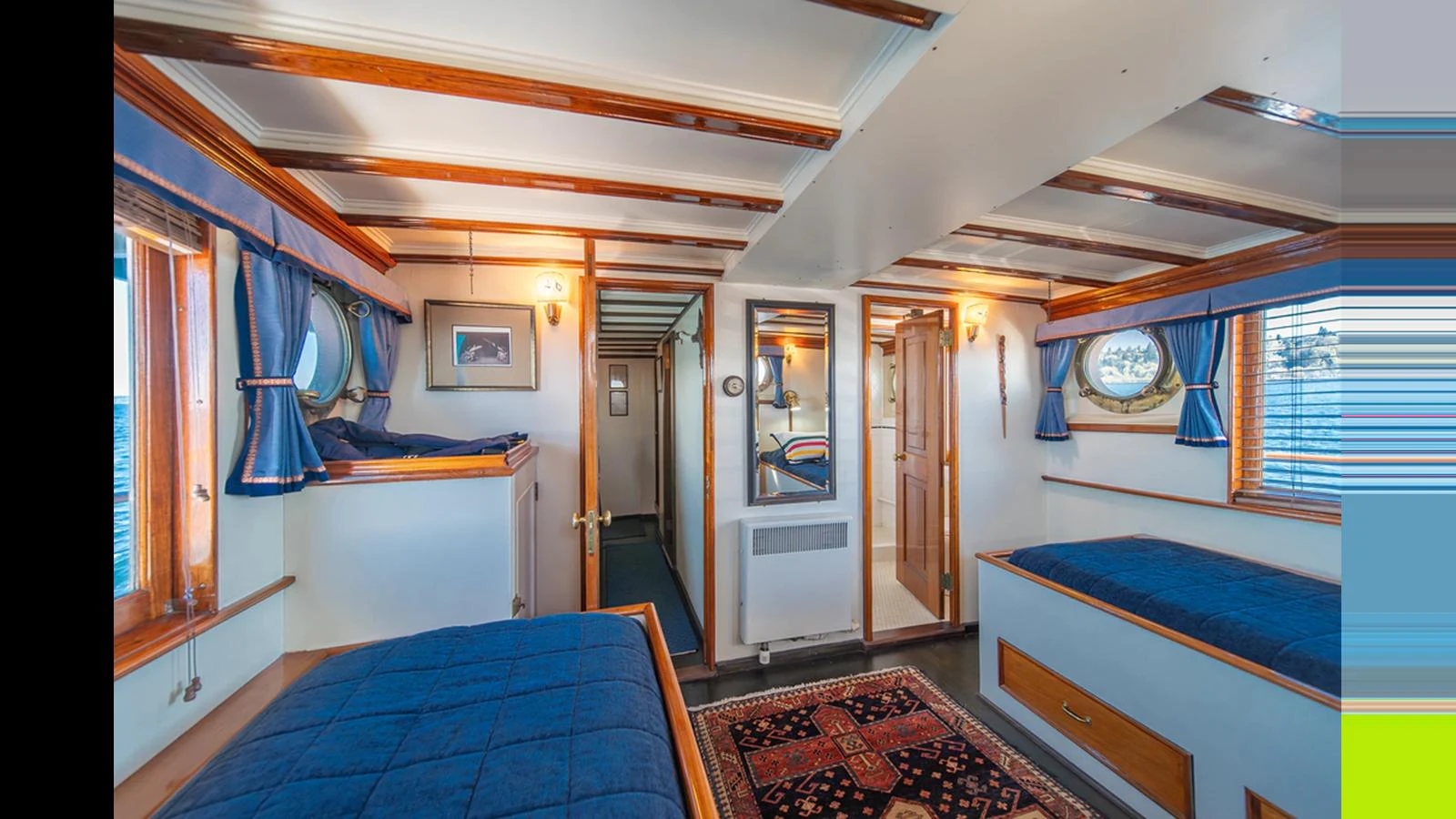 The guest cabin features cozy twin beds, nautical decor, and ample natural light. aboard BLUE PETER Yacht for Sale