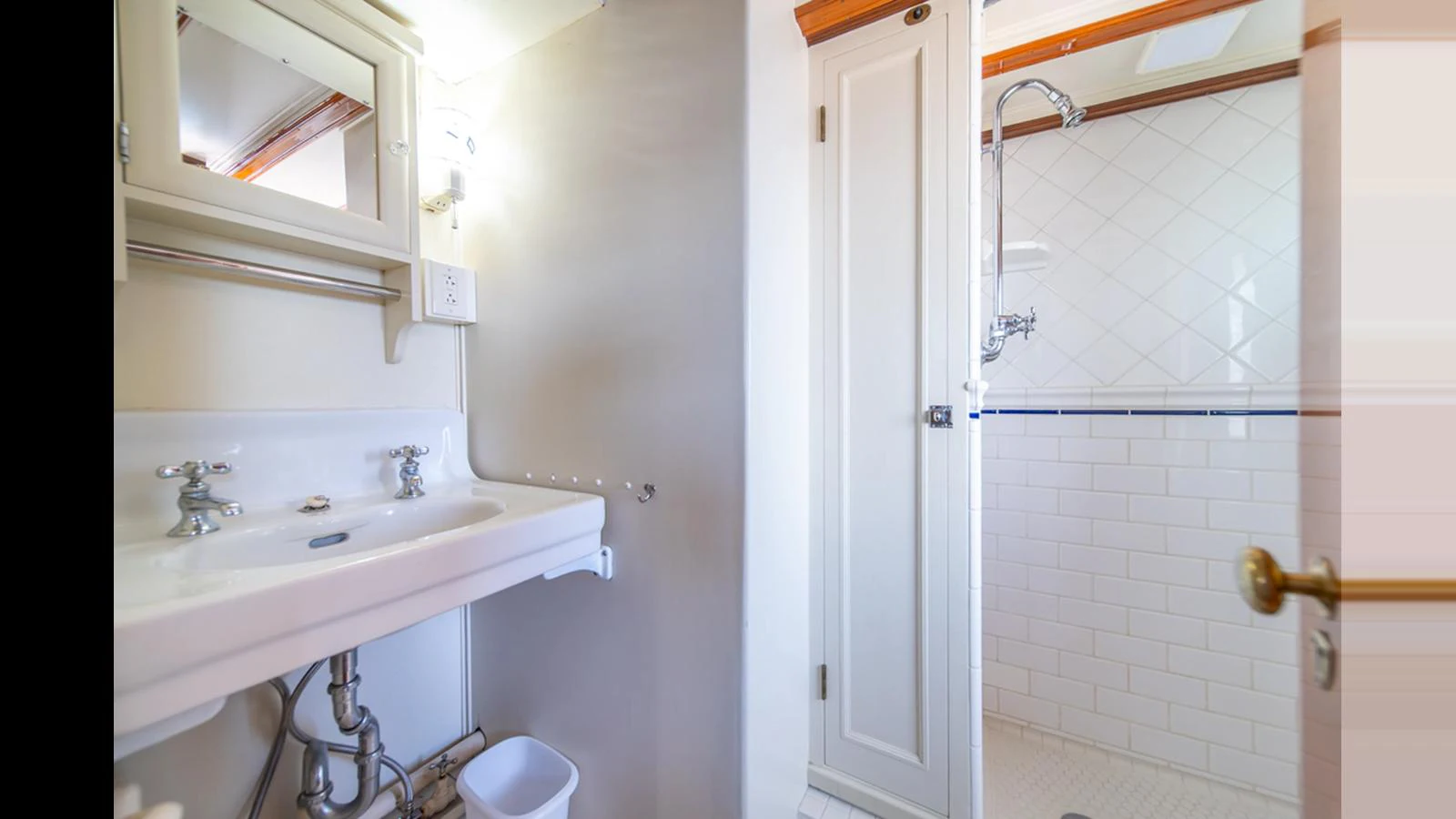 The yacht's bathroom features a clean and bright design with a white sink and a spacious shower area. aboard BLUE PETER Yacht for Sale