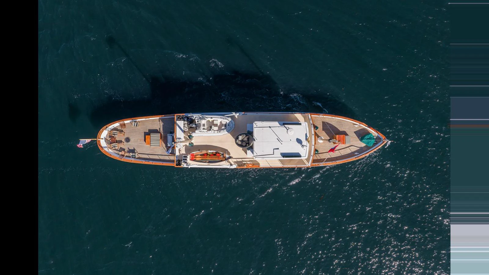 An aerial view of a sleek yacht cruising through deep blue waters. aboard BLUE PETER Yacht for Sale