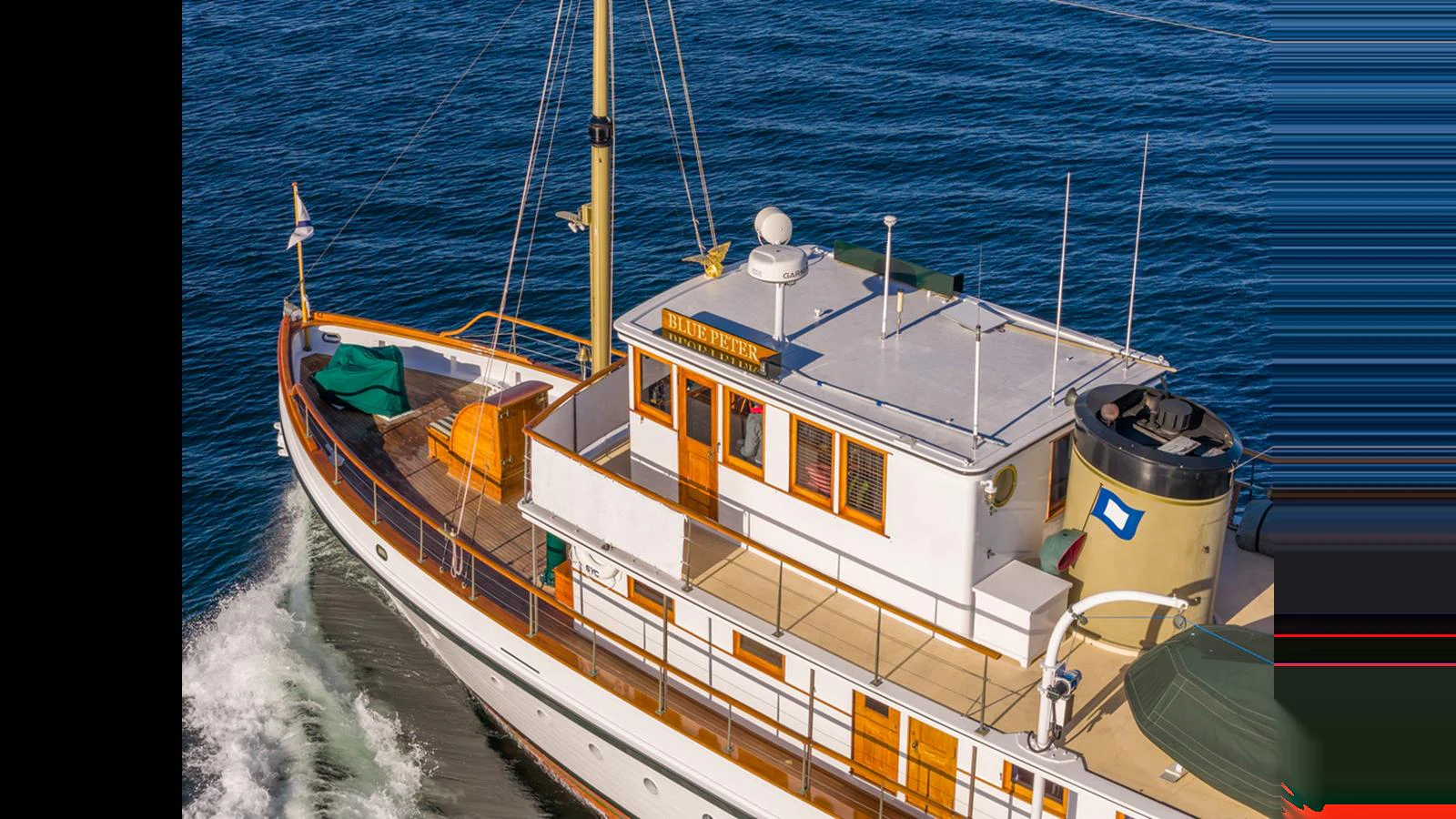 A classic yacht cruises gracefully on the open water, showcasing its timeless design and elegant wood accents. aboard BLUE PETER Yacht for Sale
