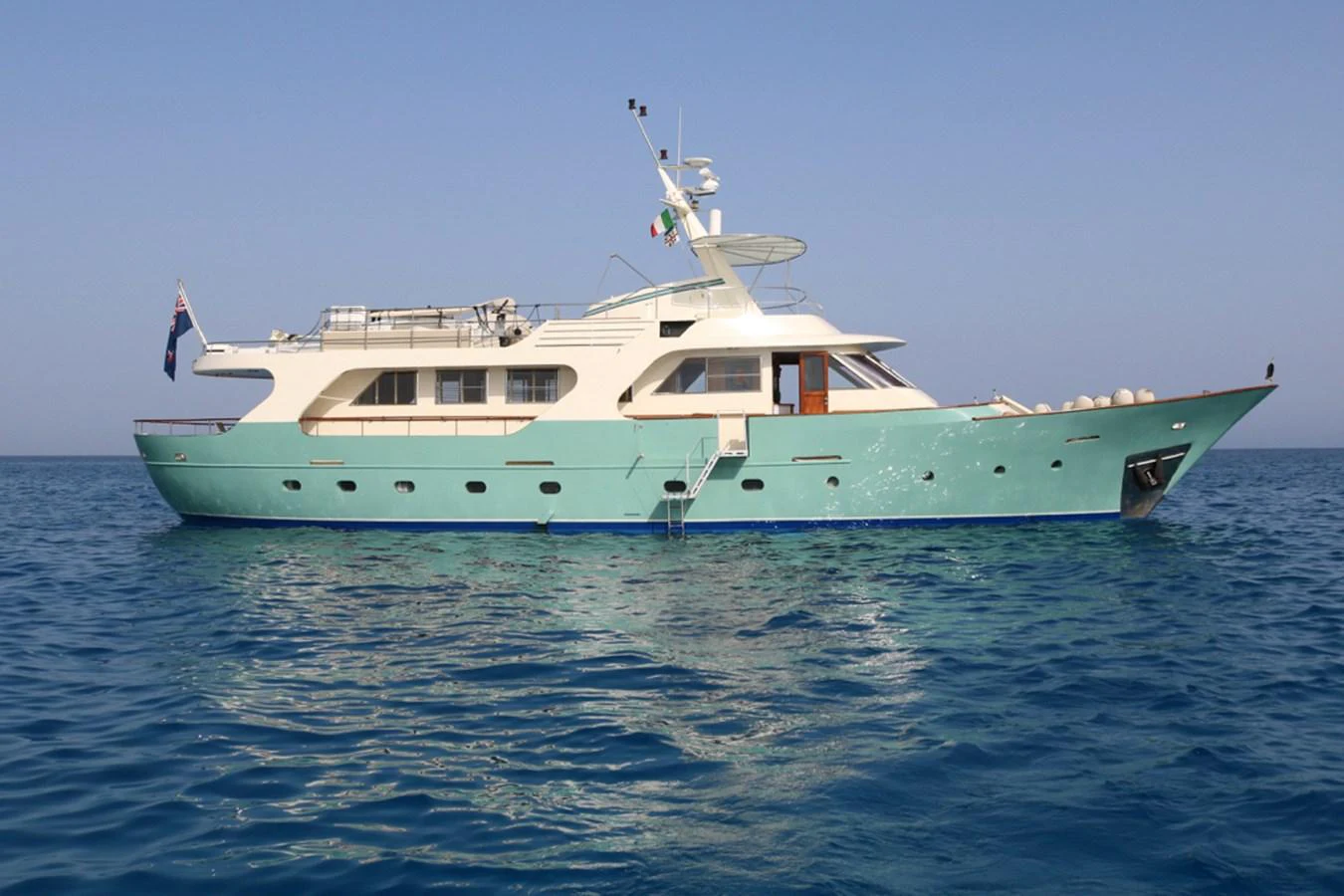 A classic yacht with a sleek design cruising on calm blue waters. aboard KALANI Yacht for Sale