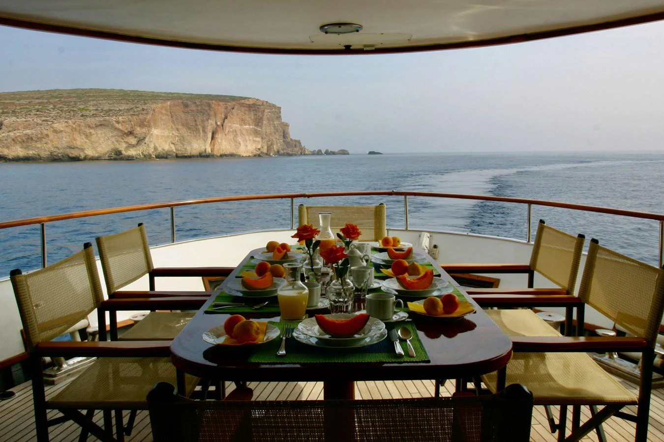 An elegant dining setup on the aft deck offers stunning views of the surrounding seascape. aboard KALANI Yacht for Sale