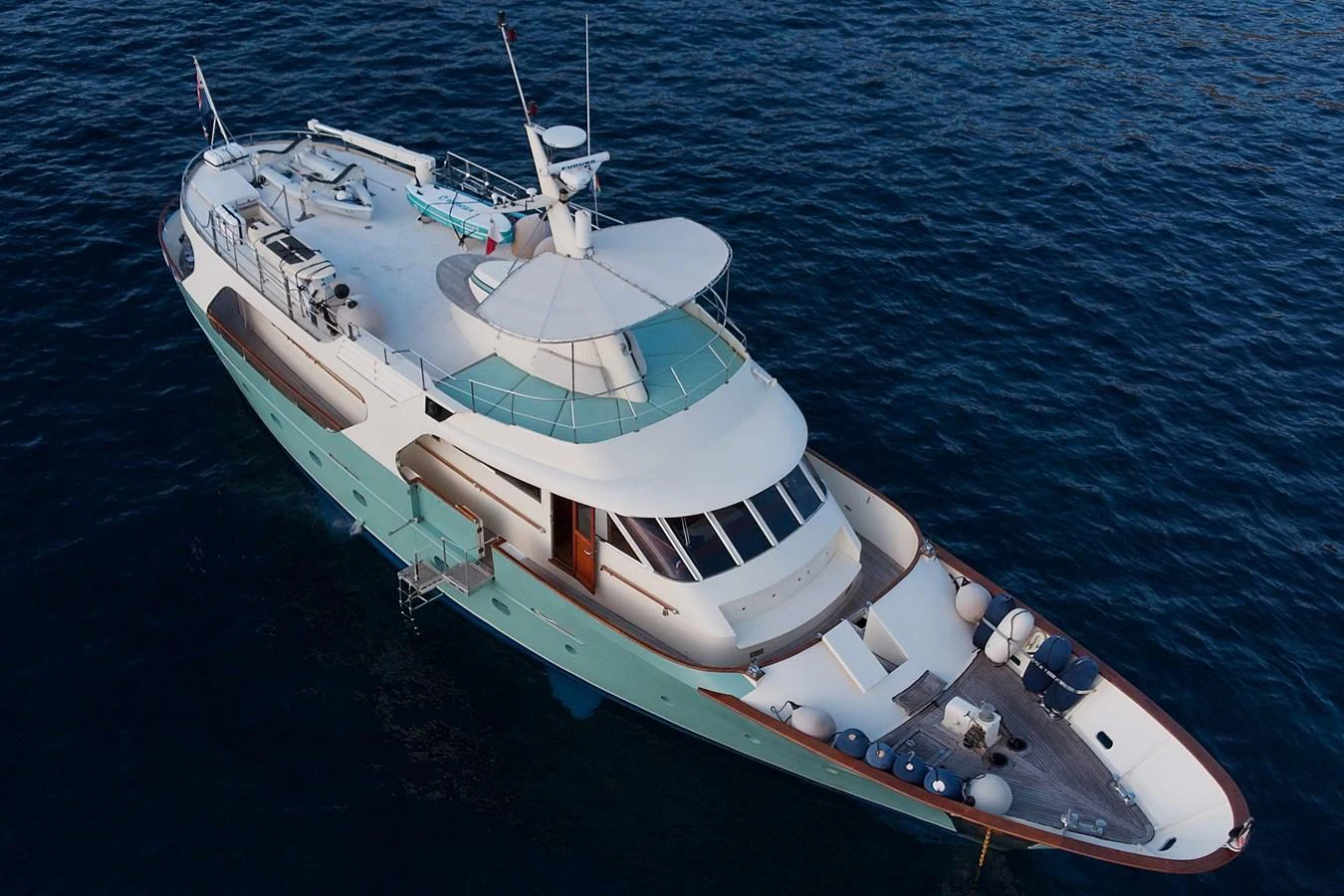 A sleek yacht cruising on calm waters, showcasing its elegant design and spacious deck areas. aboard KALANI Yacht for Sale