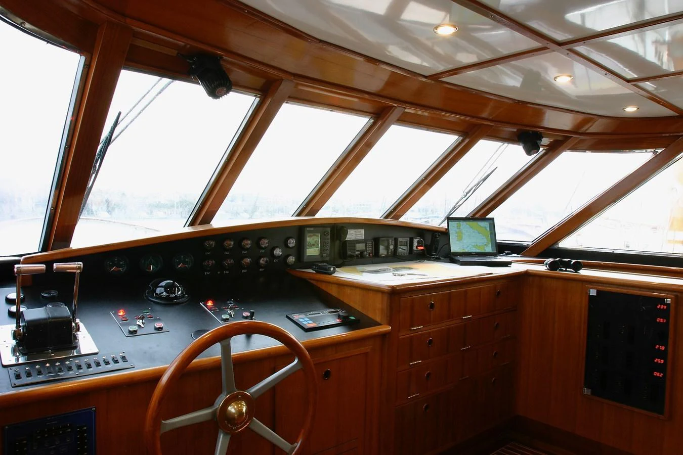 The helm station features a classic wooden design with modern navigation equipment. aboard KALANI Yacht for Sale