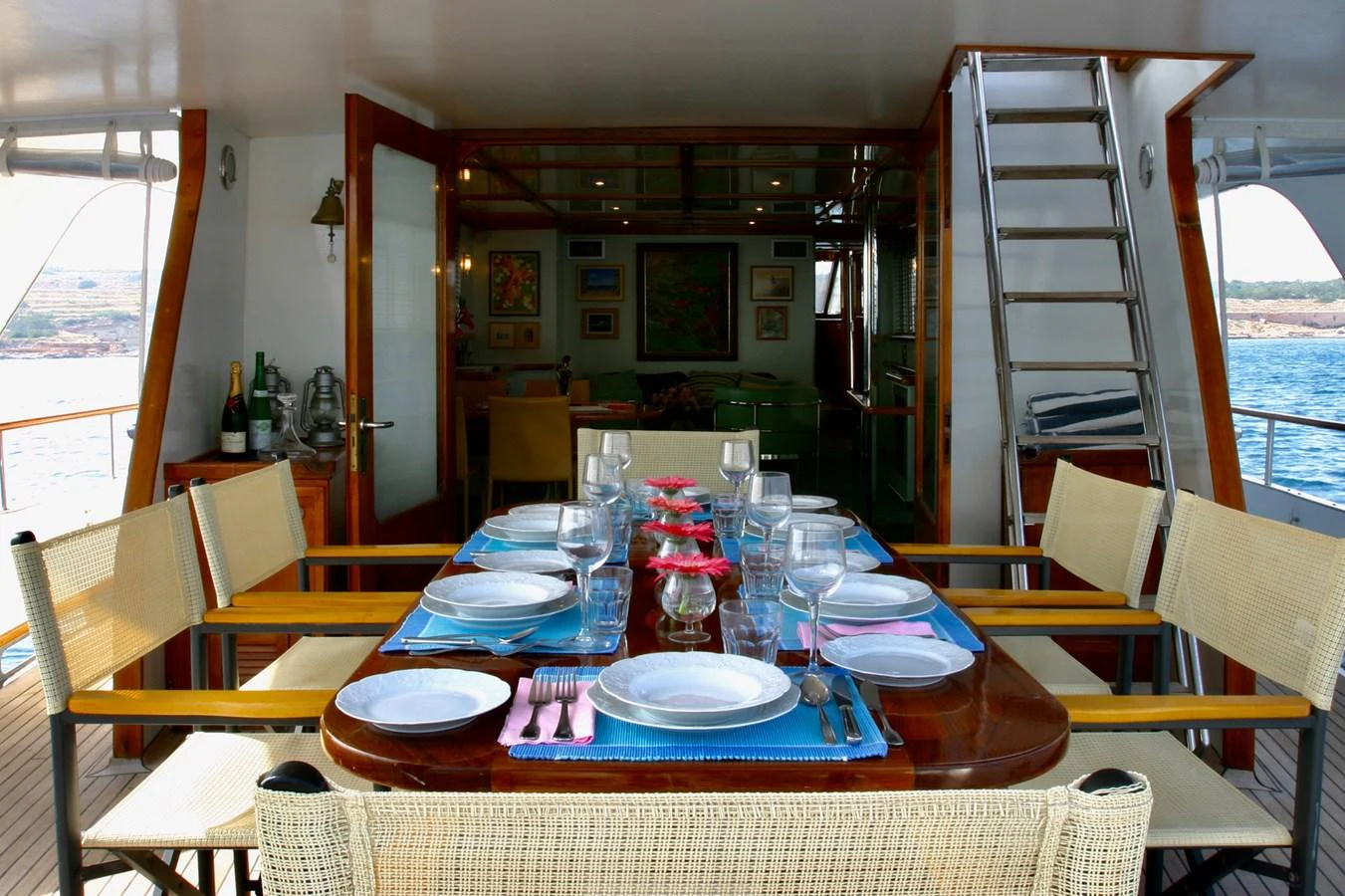 The yacht's dining area offers a beautifully set table with a view of the surrounding waters. aboard KALANI Yacht for Sale