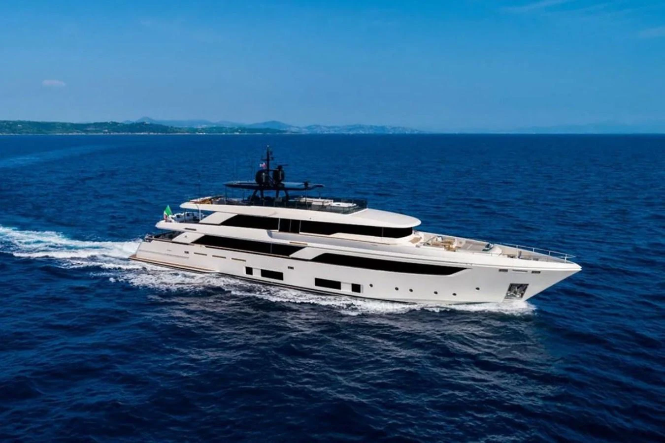 A sleek and modern yacht cruises through the open sea under a clear blue sky. aboard ALBUS Yacht for Sale