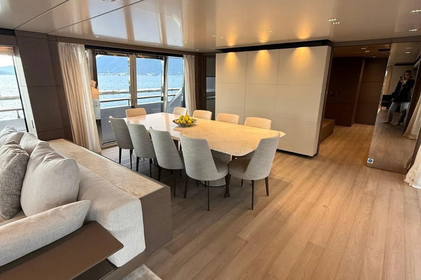 The yacht's dining area features a sleek table with comfortable seating, complemented by large windows offering stunning sea views. aboard ALBUS Yacht for Sale
