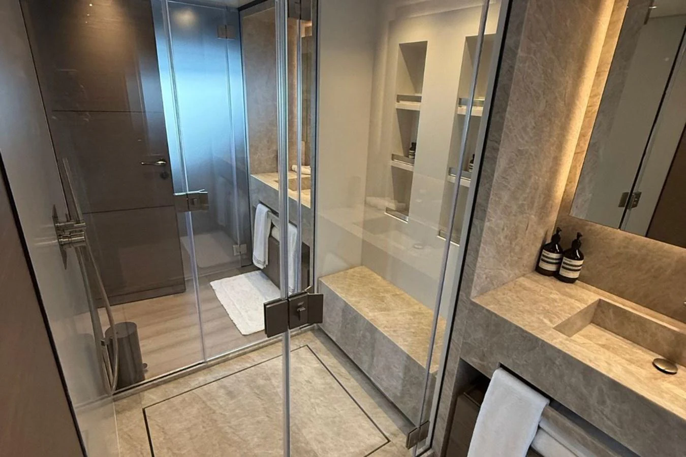 The yacht's bathroom features a sleek, modern design with glass shower doors and elegant stone finishes. aboard ALBUS Yacht for Sale
