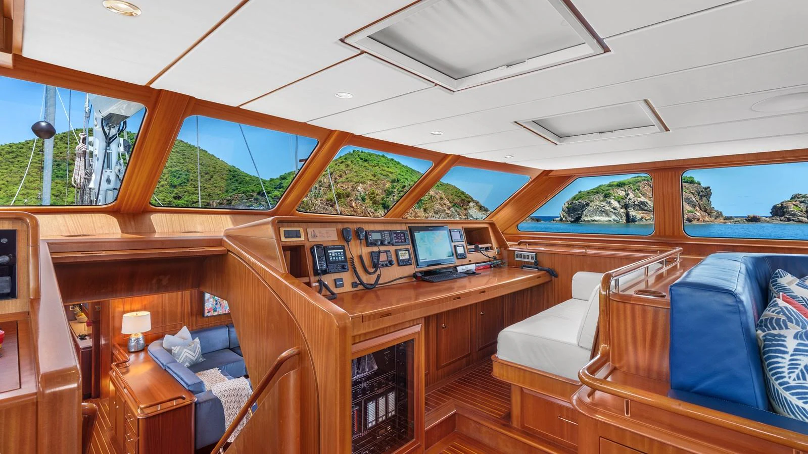 The helm station features rich wood finishes and expansive windows offering stunning views. aboard ISLANDIA Yacht for Sale