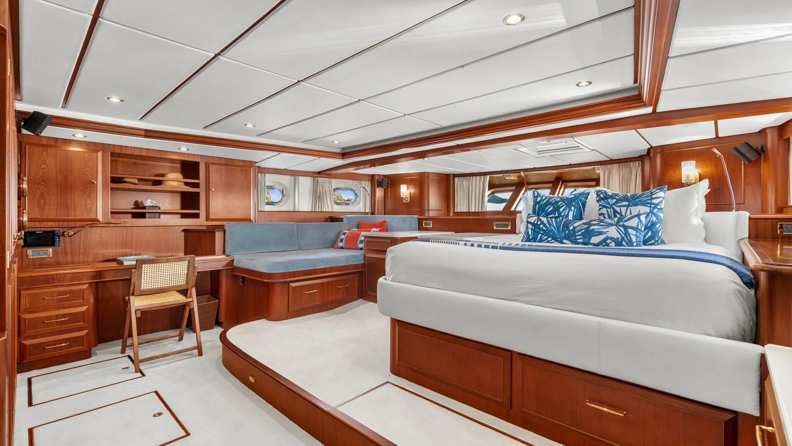 The master stateroom features a spacious layout with elegant wood finishes and luxurious bedding. aboard ISLANDIA Yacht for Sale