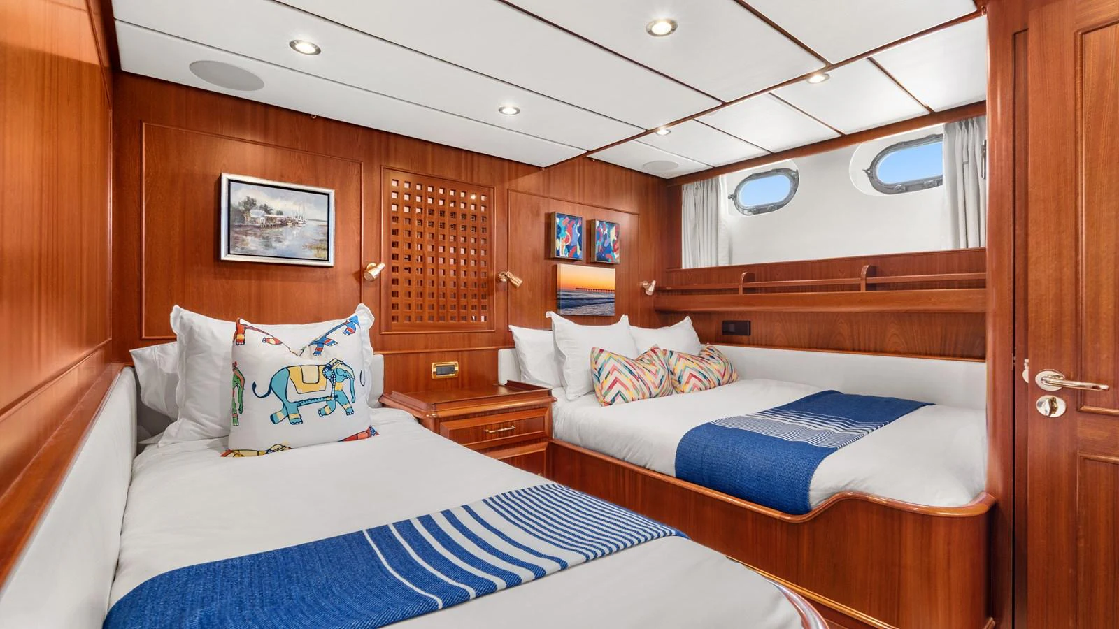 The guest stateroom features warm wood paneling and comfortable bedding with nautical accents. aboard ISLANDIA Yacht for Sale