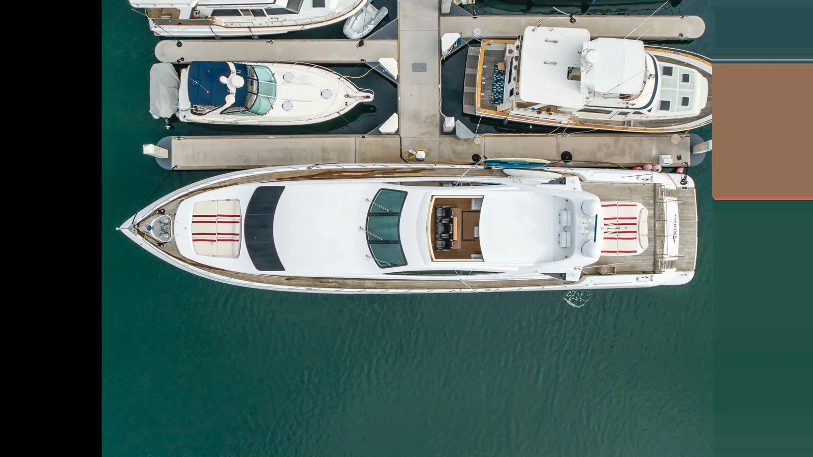 Aerial view of a sleek yacht docked at a marina, showcasing its streamlined design and spacious deck areas. aboard SAIGON Yacht for Sale