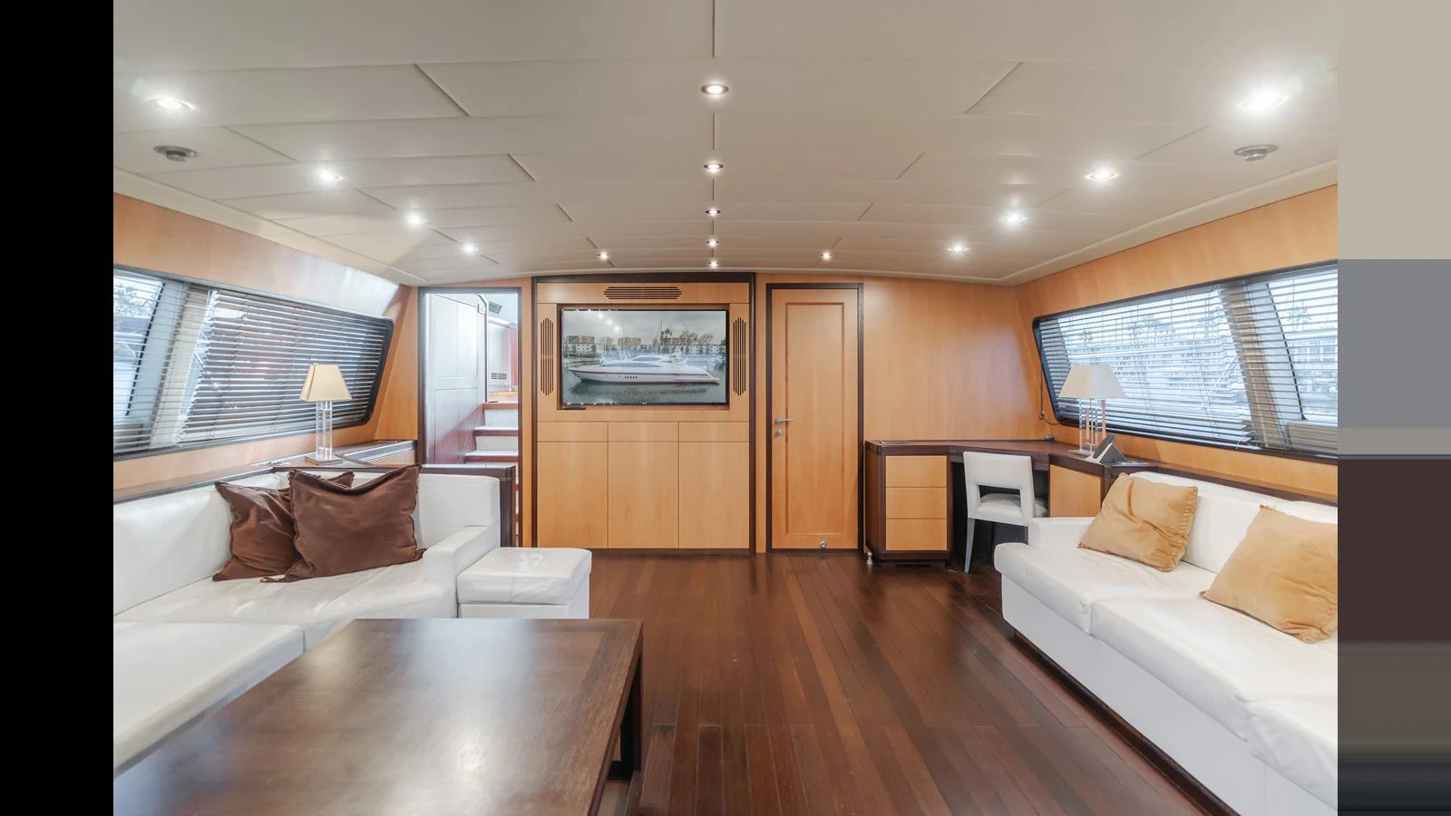 The salon features elegant wood paneling, plush seating, and ample natural light. aboard SAIGON Yacht for Sale