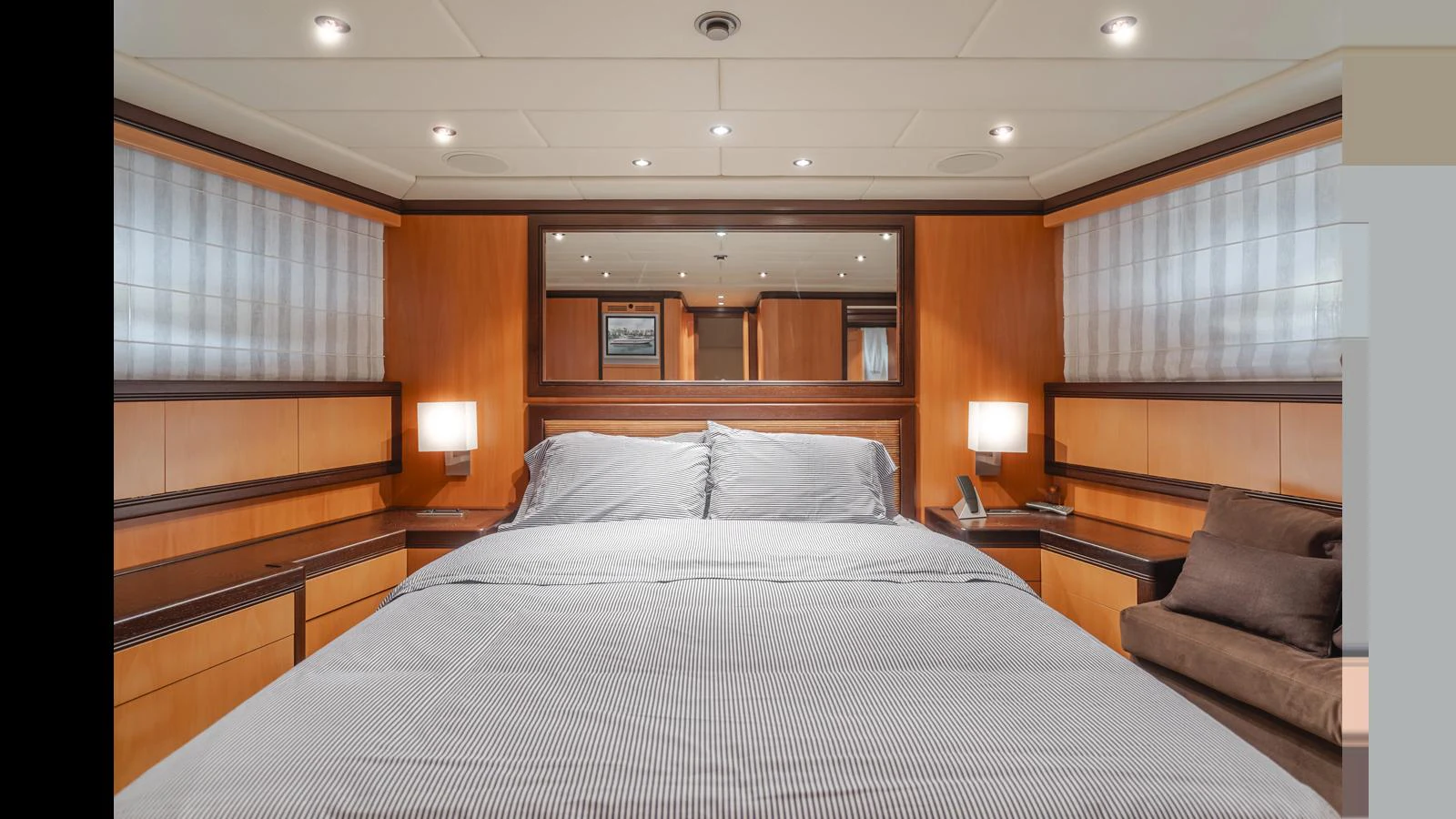 The master stateroom features a spacious bed with elegant wood paneling and soft lighting. aboard SAIGON Yacht for Sale