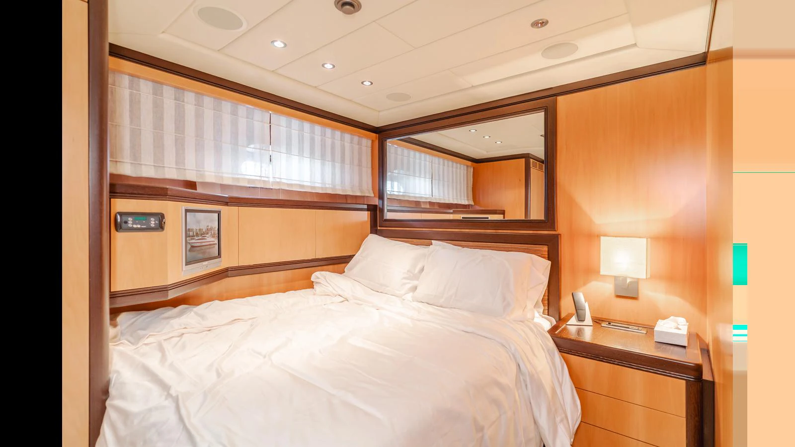 The stateroom features a cozy bed with elegant wood paneling and soft lighting. aboard SAIGON Yacht for Sale