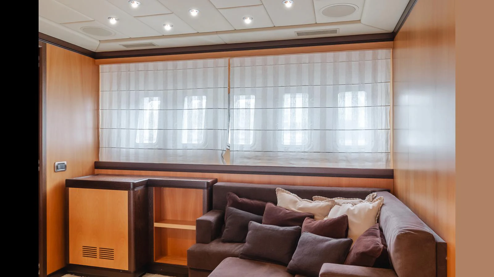 The yacht's interior features a cozy seating area with a plush sofa and ample natural light from the windows. aboard SAIGON Yacht for Sale