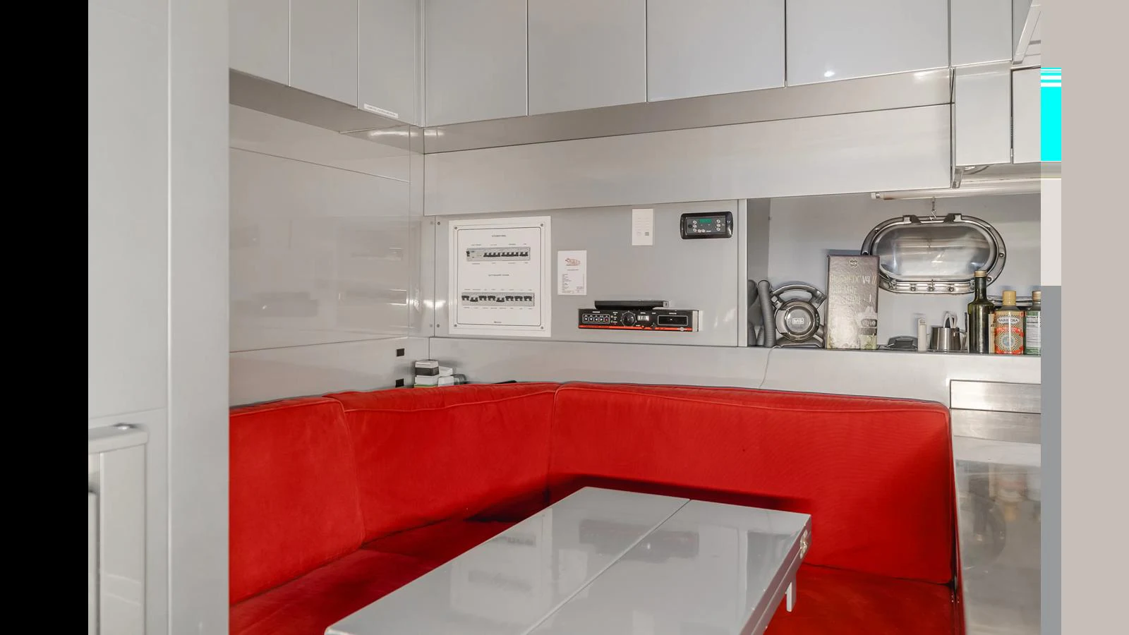 The galley features a cozy dining area with a red cushioned bench and modern appliances. aboard SAIGON Yacht for Sale