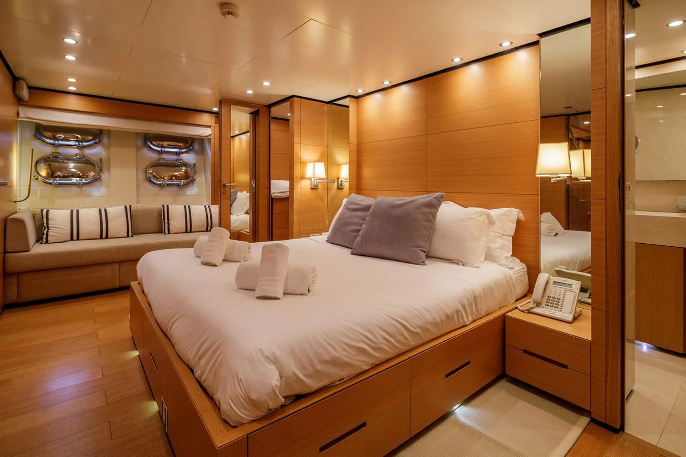 The master stateroom features a luxurious bed, cozy seating area, and elegant wooden finishes. aboard BOLARO Yacht for Sale