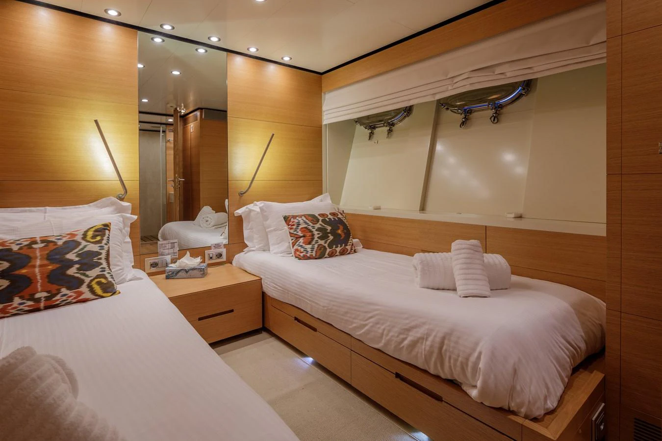 The twin stateroom features cozy twin beds with modern wooden finishes and ample natural light. aboard BOLARO Yacht for Sale