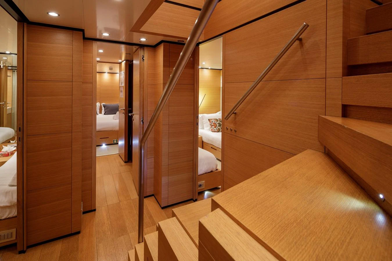 A warm and inviting hallway with wooden finishes leads to cozy staterooms. aboard BOLARO Yacht for Sale