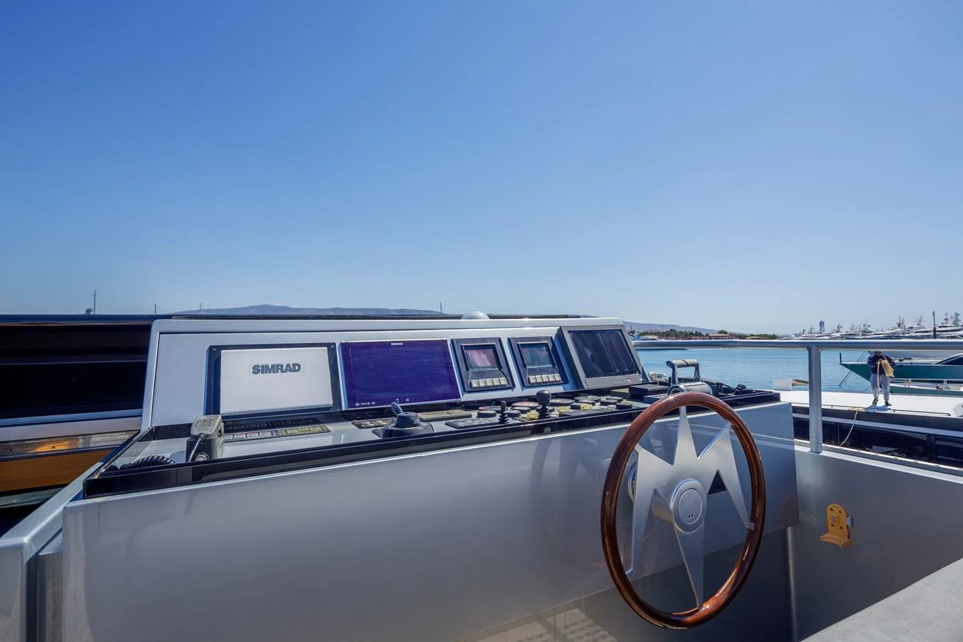The helm station features modern navigation equipment and a classic wooden steering wheel. aboard BOLARO Yacht for Sale